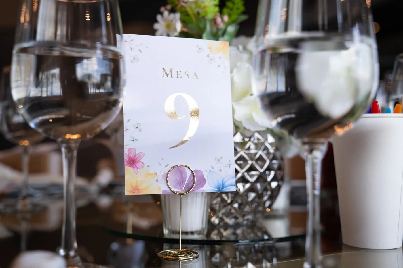 Número de mesa floral con acabado dorado en montaje de evento